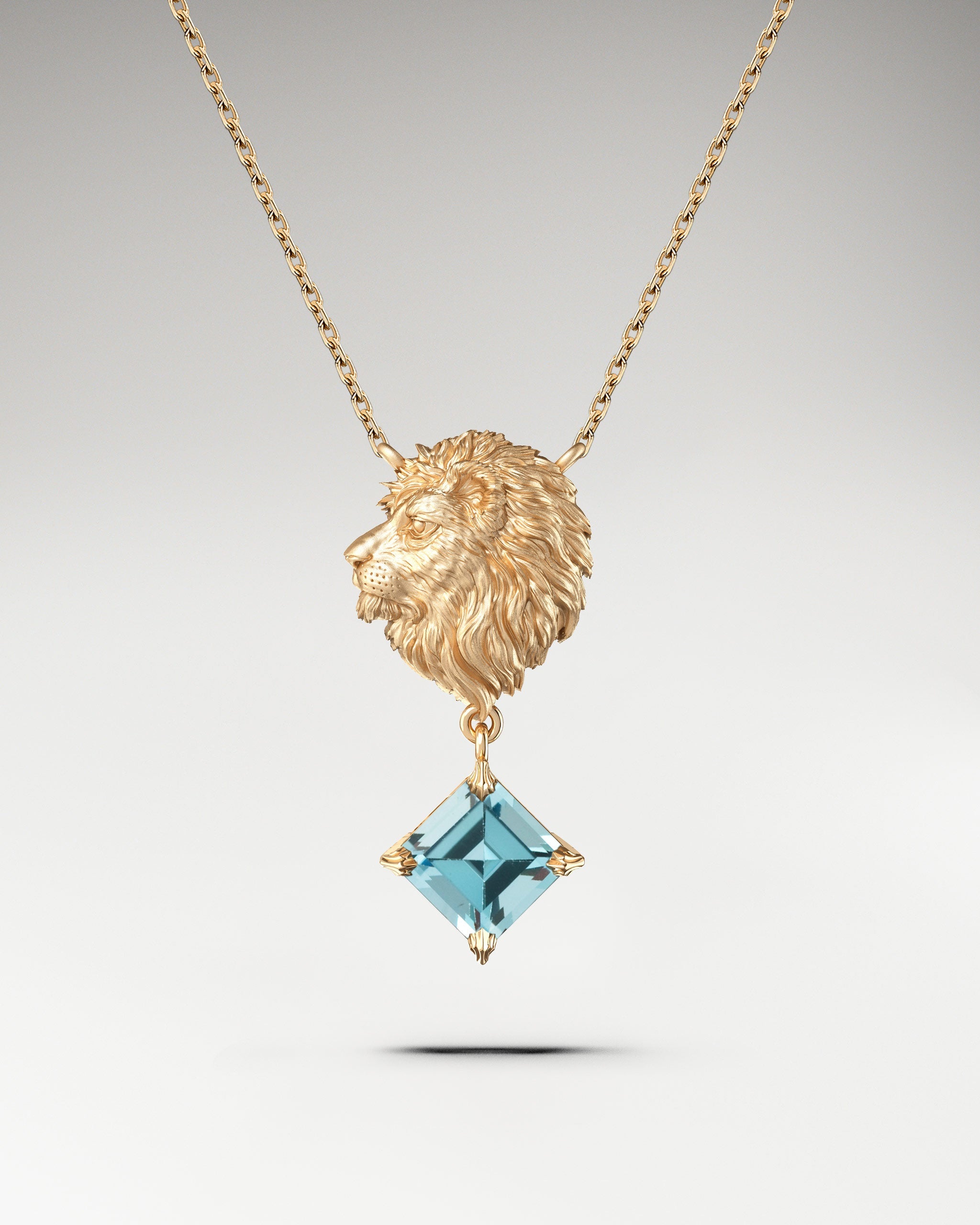 
Gold lion head pendant necklace with aquamarine gemstone.